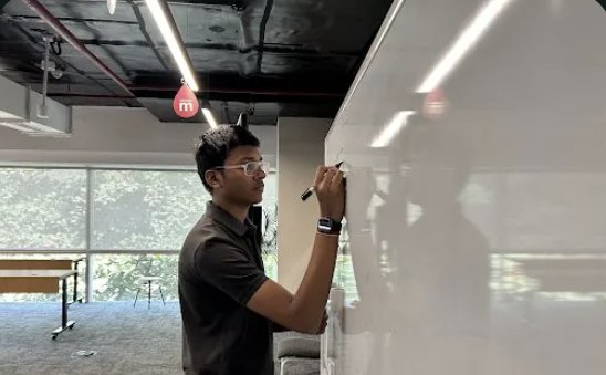 A student mapping an architecture on a whiteboard