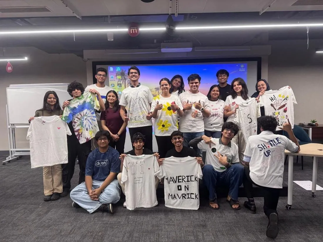 Students holding the merchandise they made