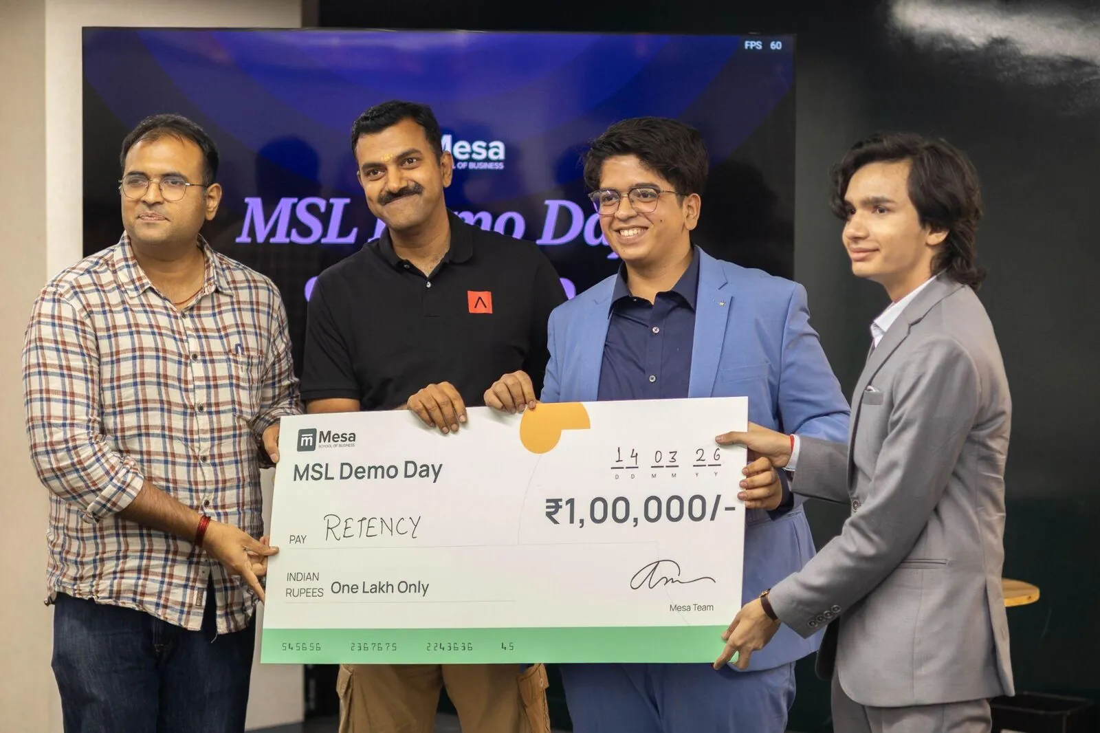 A student founder receiving a ₹1,00,000 cheque at Mesa Startup Lab Demo Day
