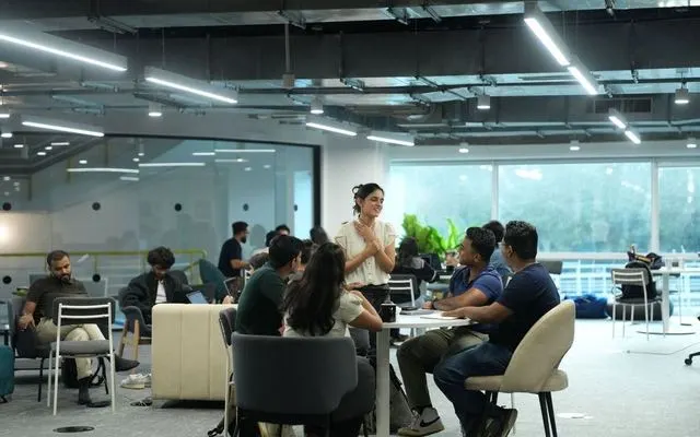 A founder briefing a group of students at a table