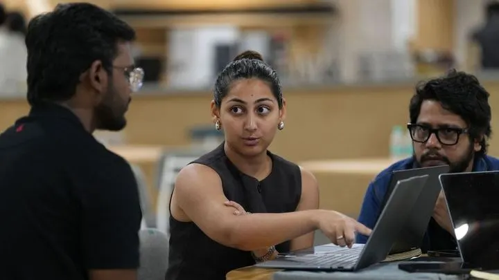 A student walking two users through her product on a laptop