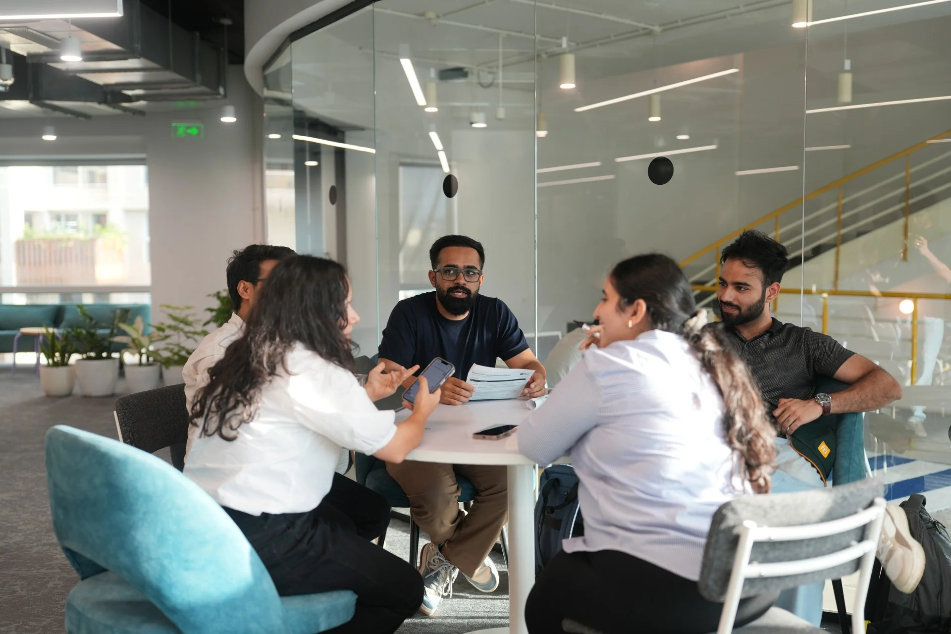 Students in discussion around a table in the common area