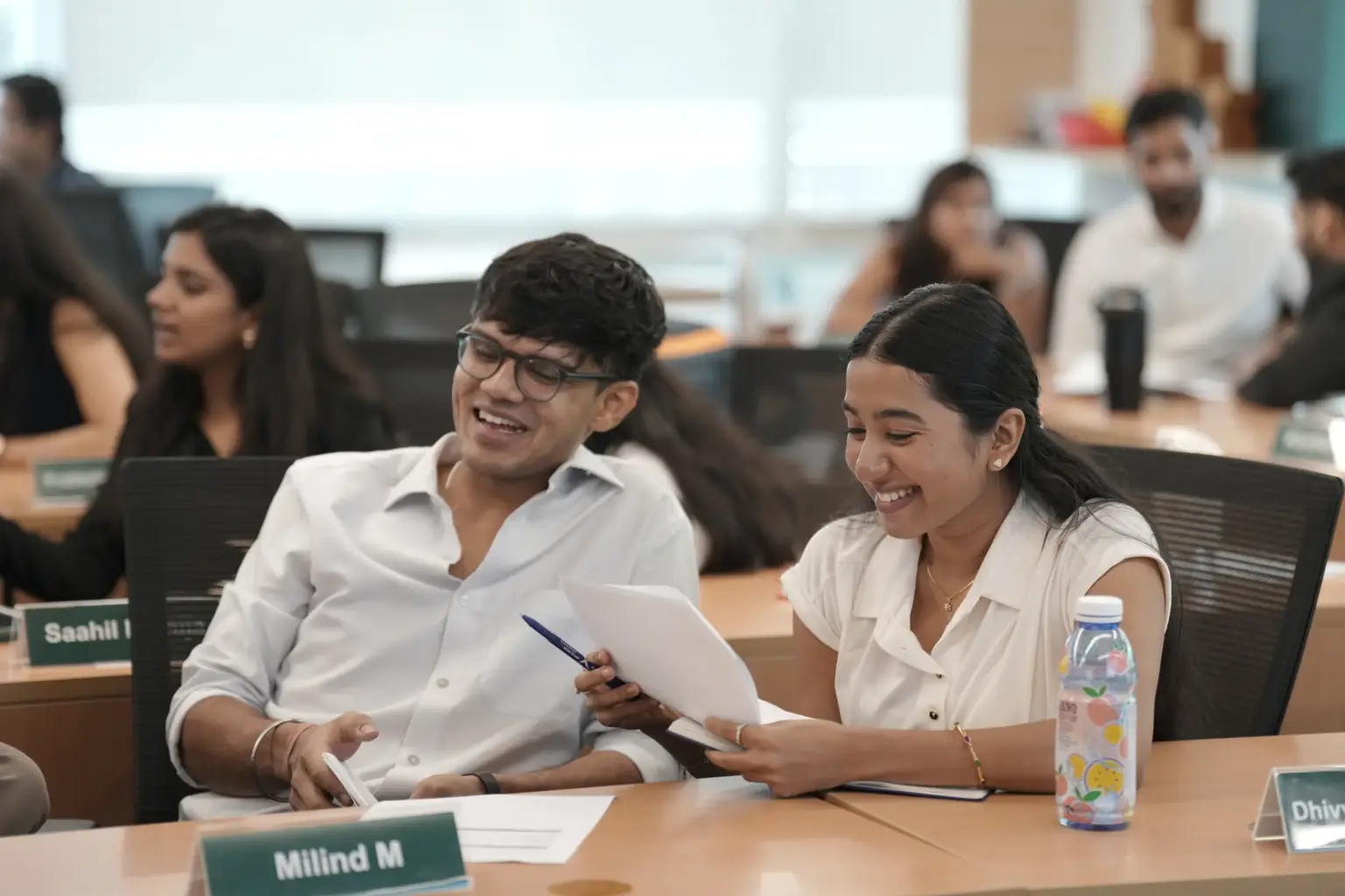 Two Mesa School of Business students discussing notes during a class
