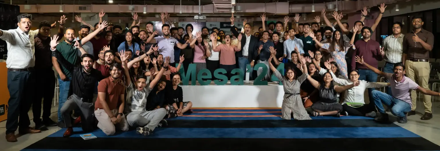 A Mesa School of Business cohort celebrating together around a Mesa '24 sign